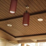 C型長條鋁板表面採木紋液體烤漆處理,展現自然質感與結構整齊的天花板設計 木紋C型長條鋁板天花,搭配嵌燈與吊燈設計,呈現溫潤質感的室外騎樓空間